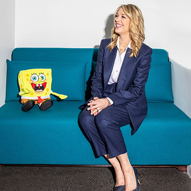 Pam Kaufman with SpongeBob Squarepants on a blue couch 