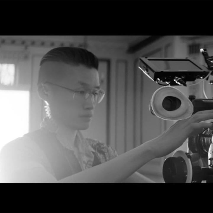A man looking through the lens of a camera