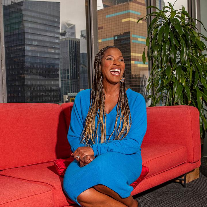 Crystal Barnes laughing on a red couch