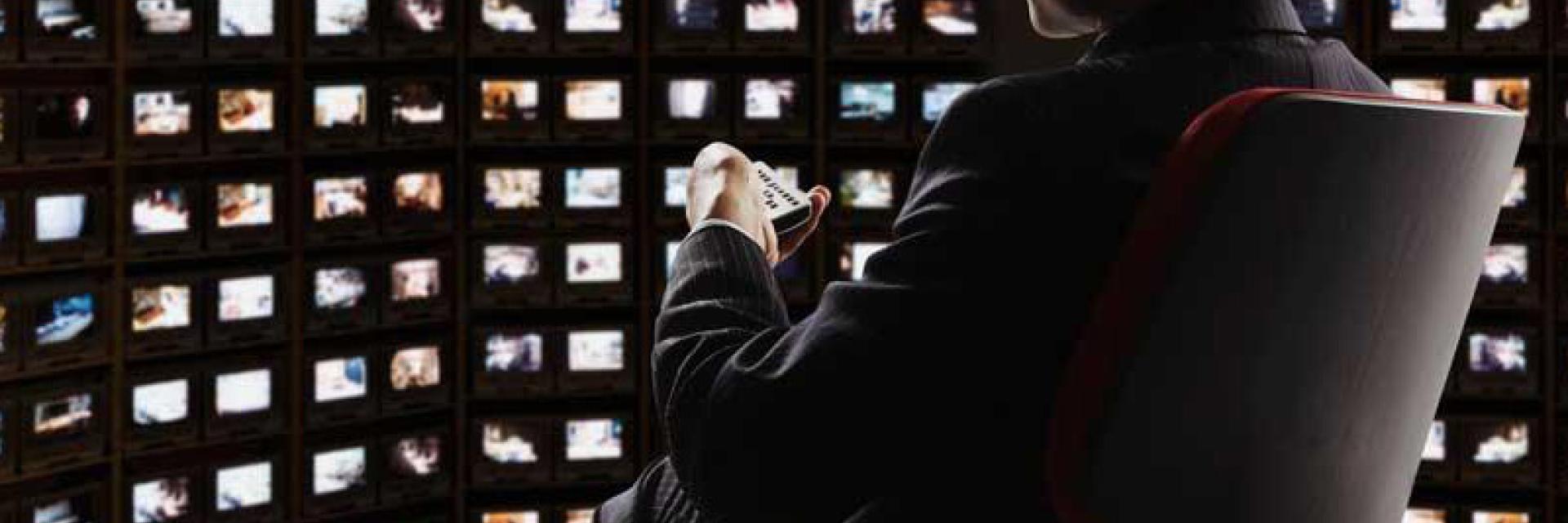Man in a room full of screens